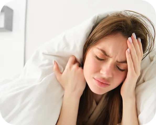 Girl holding her head with a headache, wanting to be asleep